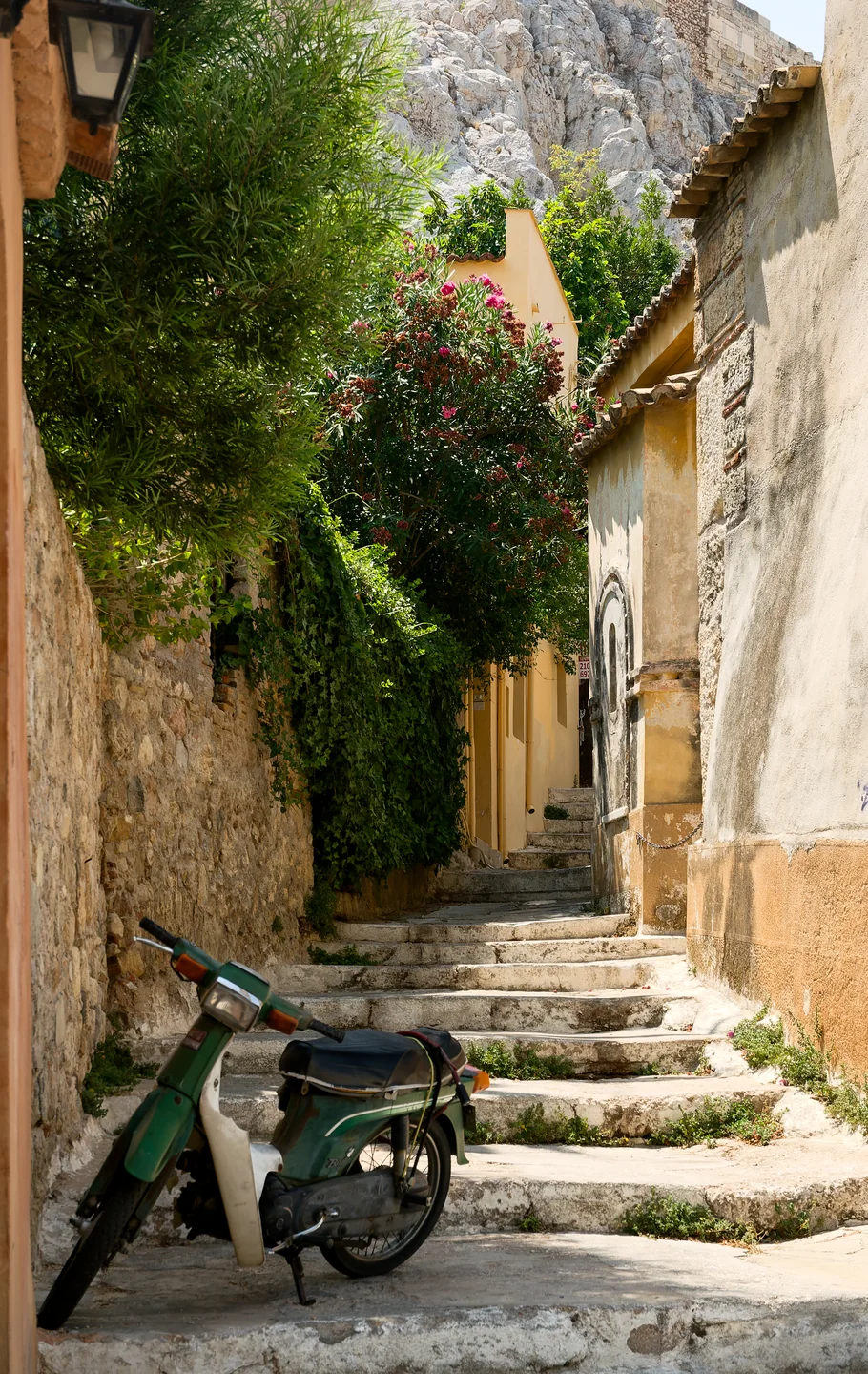 A Plaka street in Athens, between steps, greenery and historic facades.